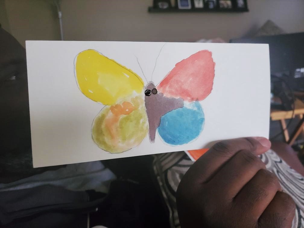 Club create member showing his watercolor butterfly close up at home