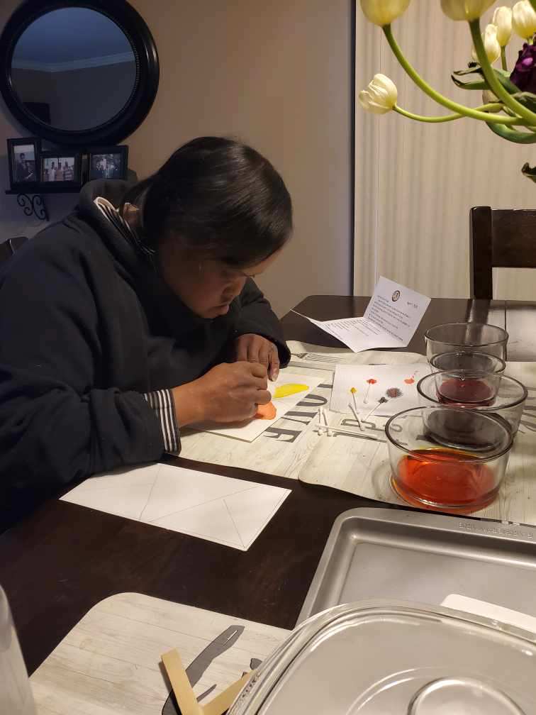Club Create member working intensly on her painting at home
