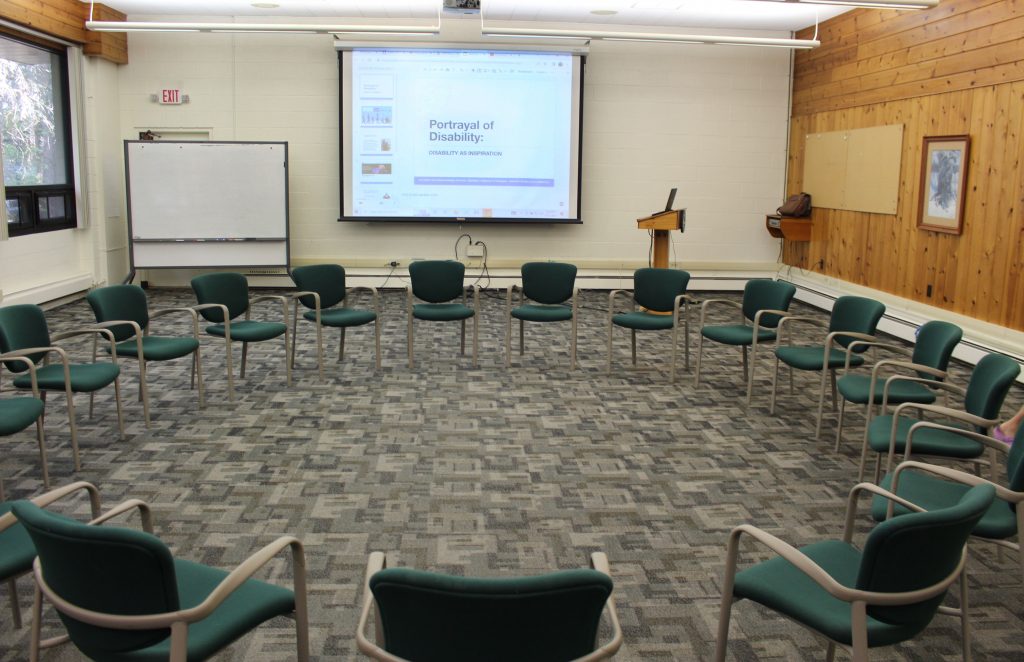 Circle of chairs in front of a powerpoint presentation. 