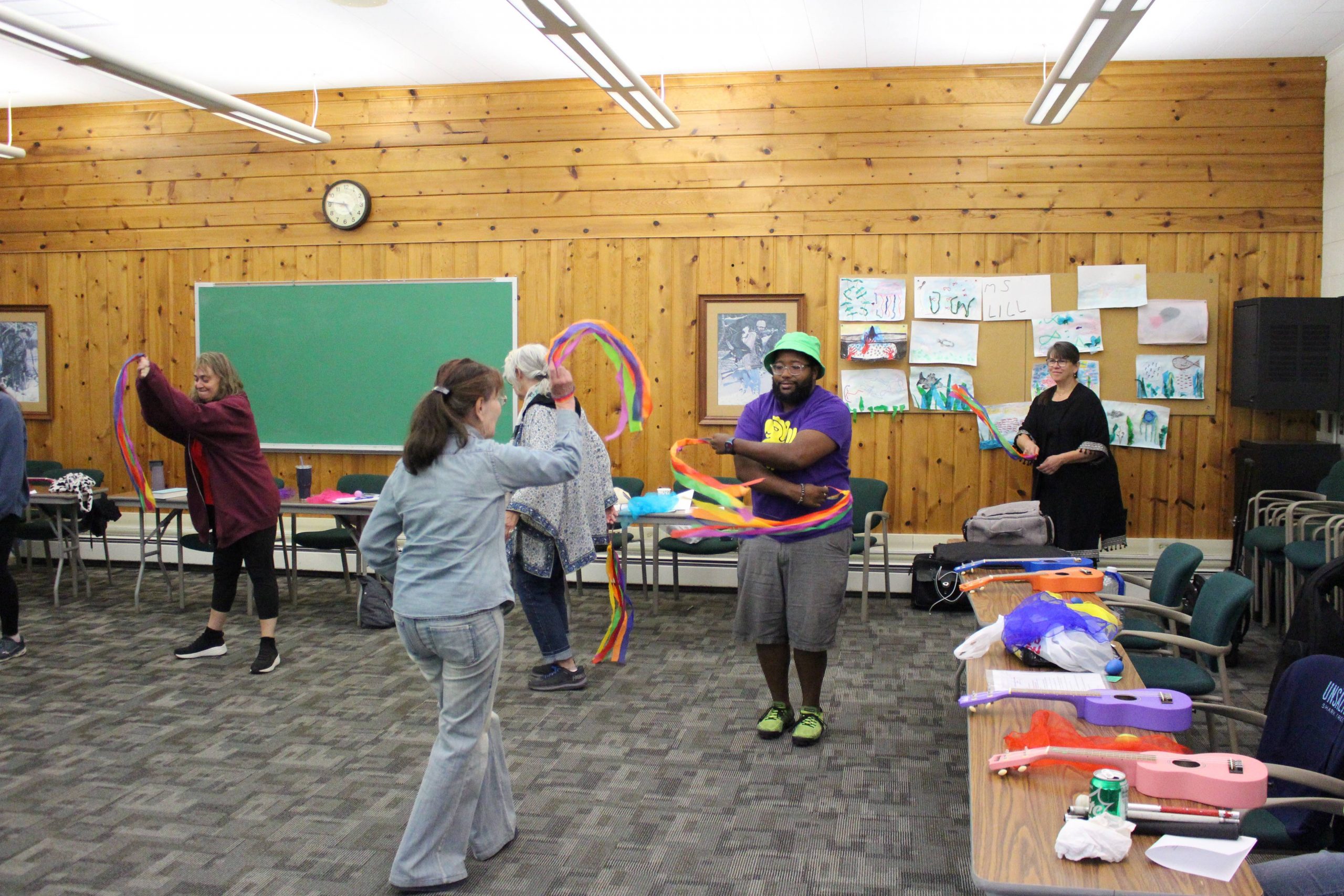 Teaching artists in a classroom using movement and colored scarfs to express themselves in a variety of ways