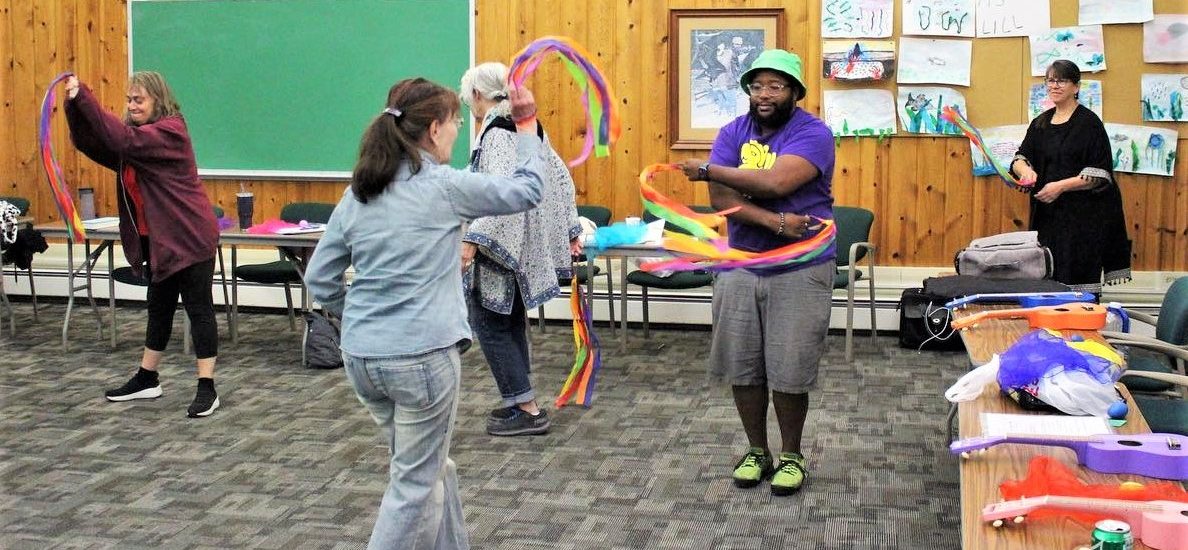 2 people facing each other moving creatively with colorful gymnastic ribbons